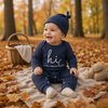 CuddleBaby – Cześć, jestem tu nowa – zestaw składający się z kombinezonu dla niemowląt i czapeczki